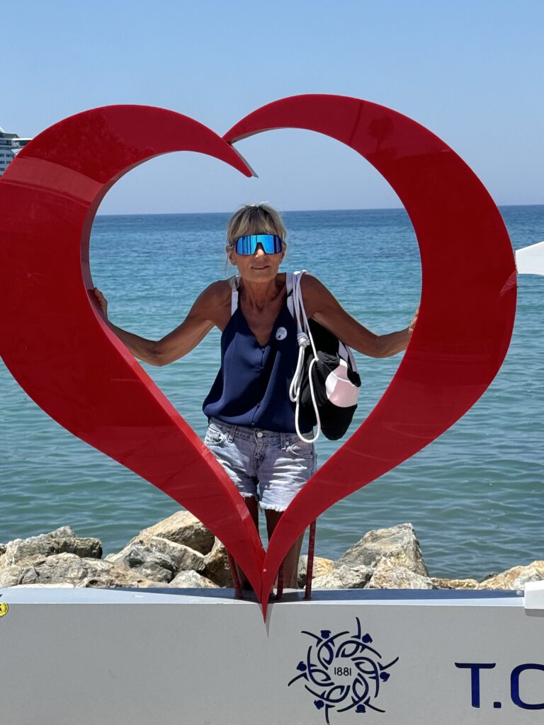 Susy davanti a un cuore rosso sul mare